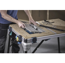 Banc de lucru cu lamă de ferăstrău circular și accesorii pe un blat de lucru