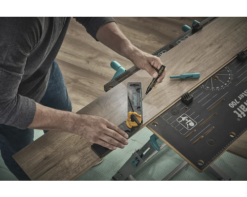 O persoană folosește un banc de lucru, un unghi și un pix pentru a prelucra o bucată de laminat.