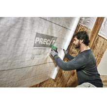 Un bărbat fixează o folie de control al vaporilor variabilă de la Precit cu un capsator în interior.