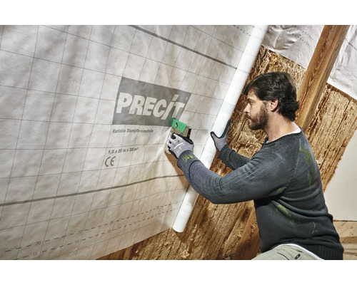 Un bărbat fixează o folie de control al vaporilor variabilă de la Precit cu un capsator în interior.