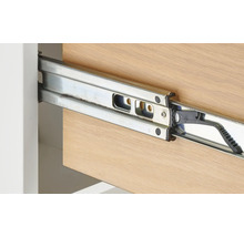 Prim-plan al unui ghidaj metalic pentru sertar pe un sertar din lemn