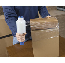 O persoană ambalează cutii de carton cu folie stretch.