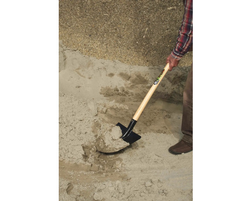 O persoană lopată nisip cu o lopată.