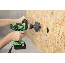 O persoană găurește o placă de lemn cu o șurubelniță cu acumulator.