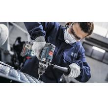 O persoană găurește un material cu o mașină de găurit fără fir.