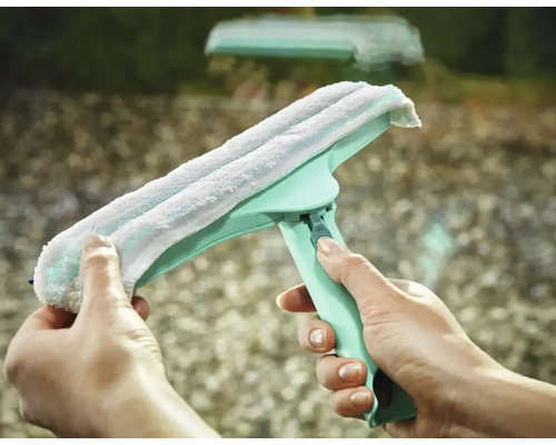 Racletă pentru geamuri cu husă din microfibră ținută în mână