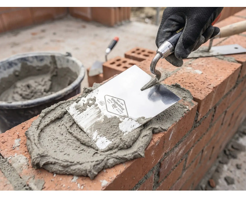 Zidar la lucru cu mistrie, mortar și cărămizi