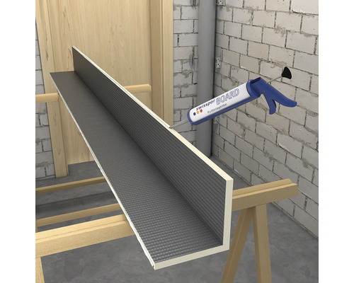 Aplicarea adezivului de montaj pe o placă de construcție pentru decorarea pereților