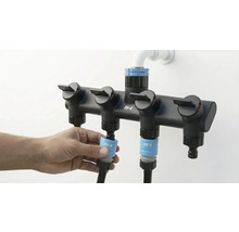 Distribuitor For Q cu patru ieșiri și o persoană care conectează un furtun