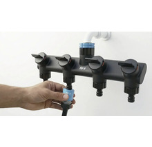 Distribuitor de apă cu patru ieșiri pentru irigarea grădinii conectat la un furtun de grădină