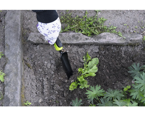 Grădinărit cu o mistrie de mână într-o grădină