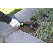 O persoană folosește o gheară de grădină pentru a afâna solul într-o grădină supraînălțată.