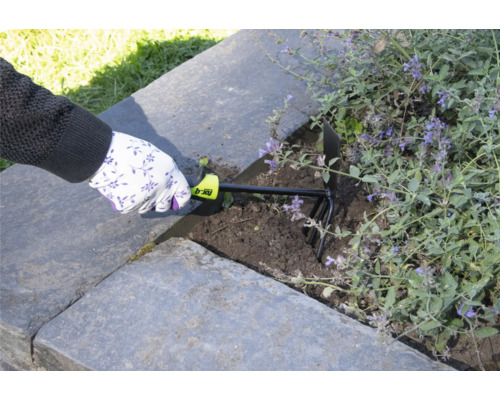 O persoană folosește o gheară de grădină pentru a afâna solul într-o grădină supraînălțată.