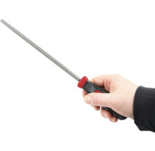 O mână ține o pilă cu mâner din plastic.