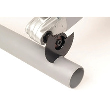 Unealtă multifuncțională cu pânză de ferăstrău circular tăind o țeavă de plastic.