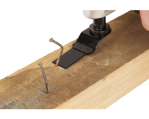 Unealtă multifuncțională cu pânză de ferăstrău taie un cui într-o grindă de lemn.