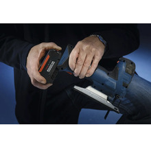 O persoană introduce un acumulator din sistemul Bosch Professional 18 volți într-un ferăstrău pendular.
