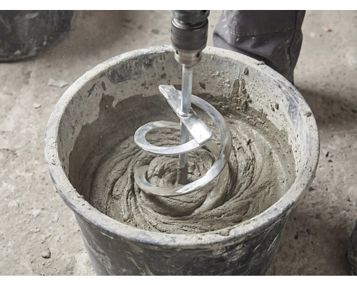 Un malaxor cu spirală amestecă mortar gri într-o găleată neagră de șantier.