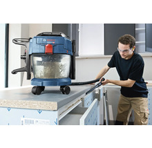 Aspirator cu acumulator Bosch pentru aspirare umedă și uscată, utilizat pentru curățarea unui banc de lucru într-un atelier luminos.