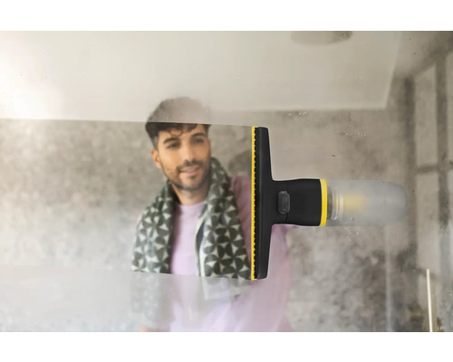 Un aspirator electric de geamuri îndepărtează condensul de pe o suprafață de sticlă din baie, lăsând o urmă curată.