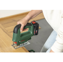 O persoană taie o bucată de parchet laminat cu un ferăstrău vertical cu acumulator Bosch EasySaw 18V-70.