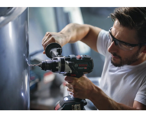 Meșter care găurește o suprafață metalică cu o mașină de găurit și înșurubat cu acumulator Bosch Professional.