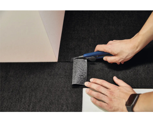 Montarea mochetei: tăierea pardoselii cu un cutter la colțul peretelui.