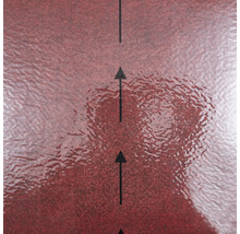 Suprafață roșie texturată a unui material de construcție cu săgeți negre care indică direcția de montare.