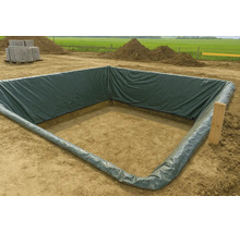O groapă pătrată de construcție căptușită cu o folie PE verde închis pe un șantier cu grămezi de pământ în fundal.