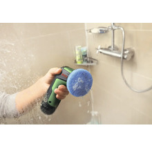 O persoană curăță o cabină de duș cu dispozitivul de curățare fără fir Bosch și un accesoriu de burete albastru.