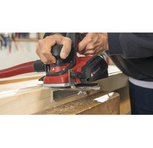 Rindea electrică Einhell pentru prelucrarea unei grinzi de lemn cu furtun de aspirare conectat într un atelier.