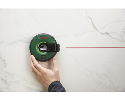 Logo Bosch. Nivelă laser cu linii verzi cu linie laser roșie pe un perete.