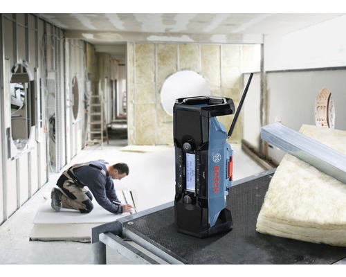 Radio de șantier Bosch pe un șantier, un muncitor în fundal.