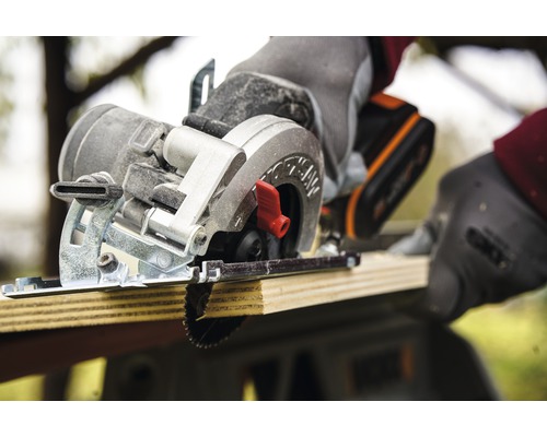 Fierăstrău circular manual cu acumulator tăind o scândură de lemn