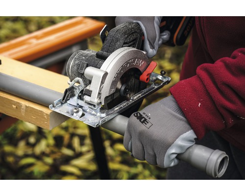 Fierăstrău circular manual tăind o țeavă de plastic pe un banc de lucru