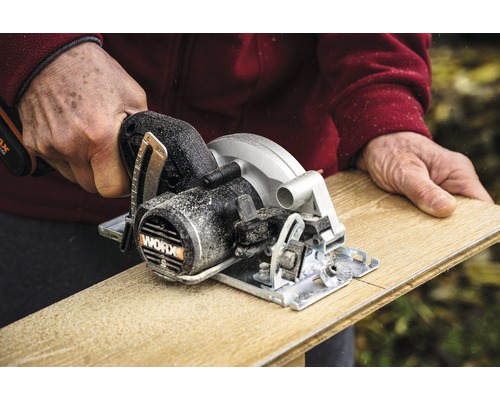 O persoană taie o scândură de lemn cu un ferăstrău circular manual WORX.