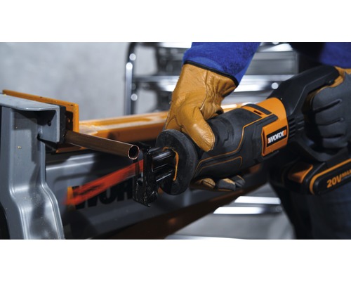 O persoană taie o țeavă de cupru cu un ferăstrău vertical de la Worx.