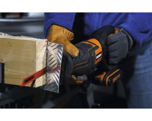 O persoană taie o bucată de lemn cu placare metalică folosind un ferăstrău oscilant. Unealta este de la Worx.