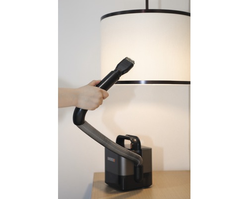 Aspirator cu accesoriu perie utilizat pe un abajur