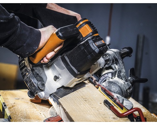 Un fierăstrău circular taie o piesă de lucru din lemn. Logo Worx.