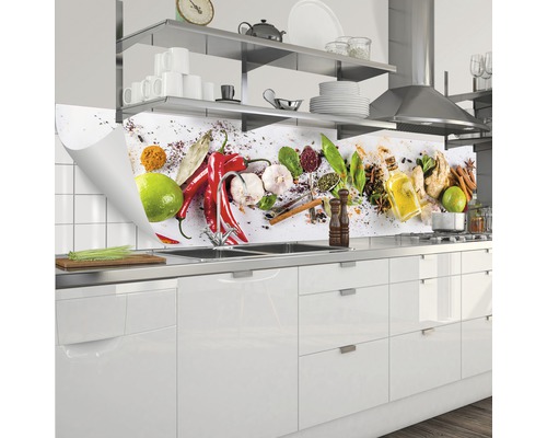 Protecție perete bucătărie cu motive de condimente în spatele unei chiuvete într-o bucătărie