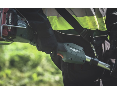 O persoană care poartă un trimmer cu acumulator Metabo peste umăr.