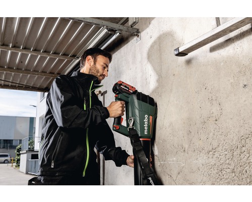 Un bărbat folosește un dispozitiv de localizare Metabo pe un perete.