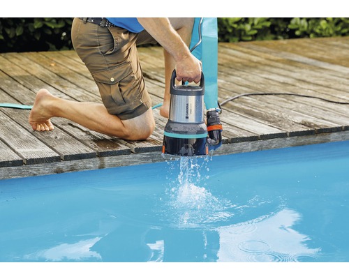 Un bărbat evacuează apa dintr-o piscină cu o pompă de apă murdară Gardena.