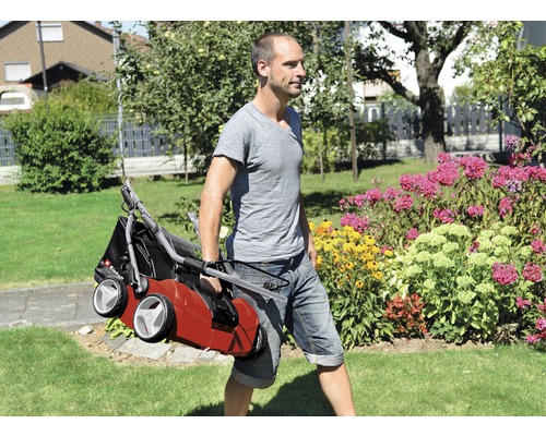 O persoană care poartă un scarificator printr-o grădină.