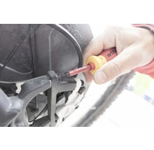 O persoană folosește o șurubelniță pe o bicicletă.