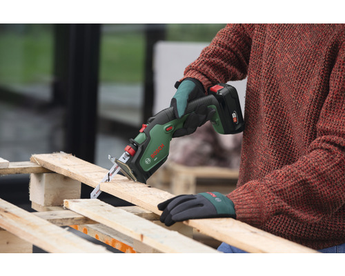 Persoană taie lemn cu un fierăstrău electric cu acumulator Bosch