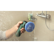 O persoană curăță un perete de duș cu o perie electrică de curățare.