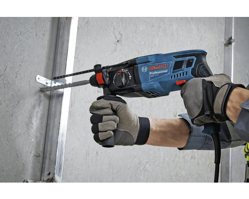 O persoană găurește un perete cu un ciocan rotopercutor Bosch.