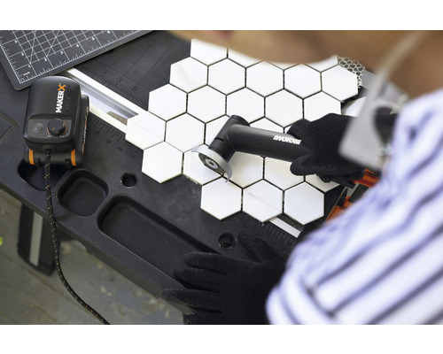 O persoană taie plăci hexagonale cu un instrument de la Worx